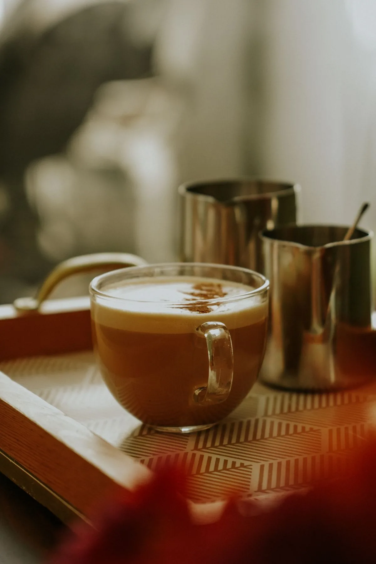 Milk frother beside a foamy latte showing frothing technique for cold foam