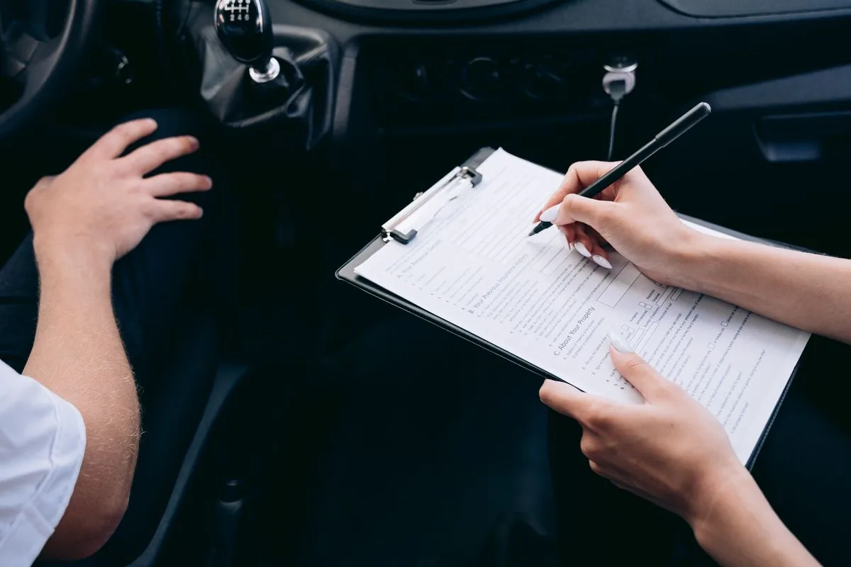 Signing new car insurance paperwork inside a car during a switch