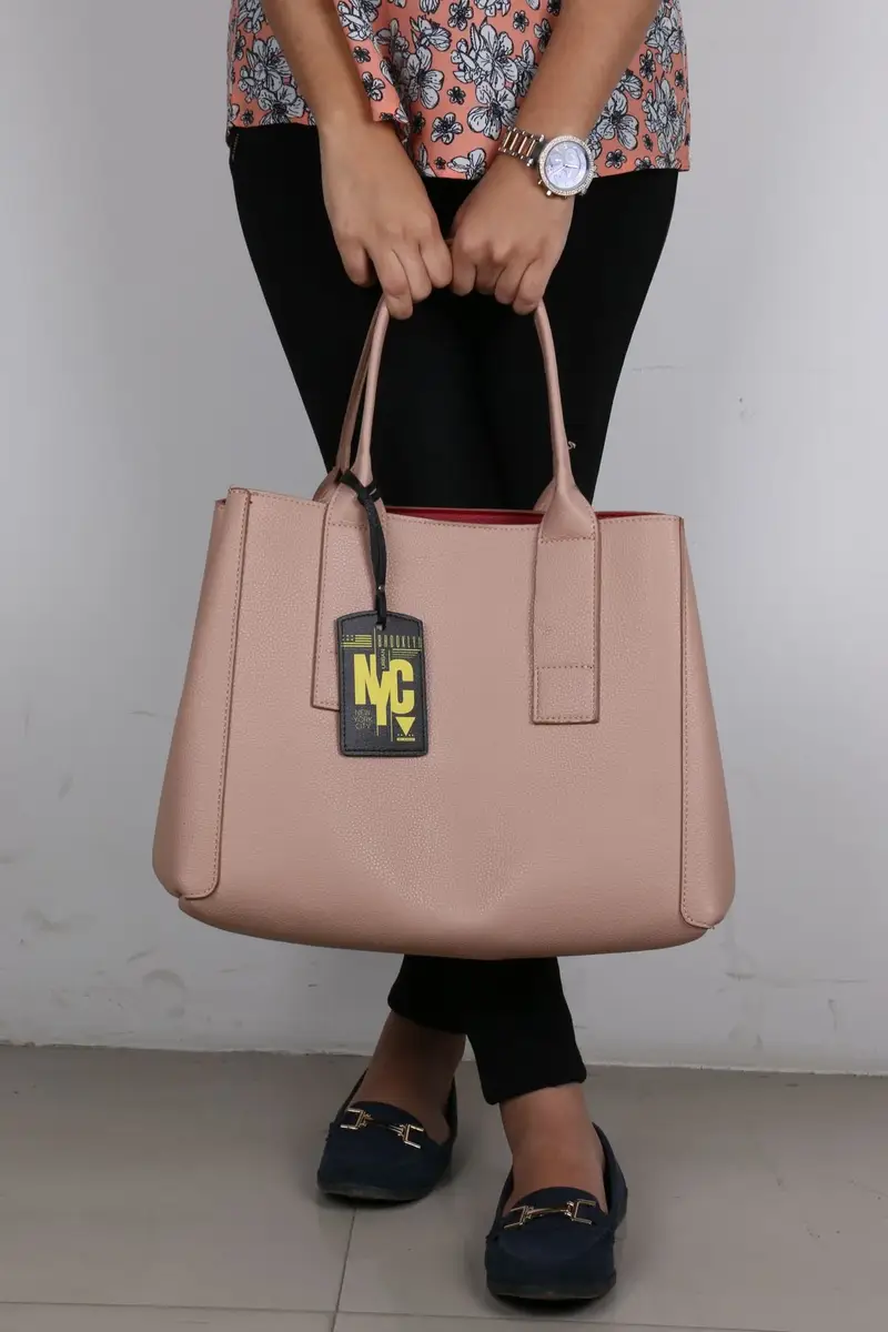 Model holding a stylish beige tote bag