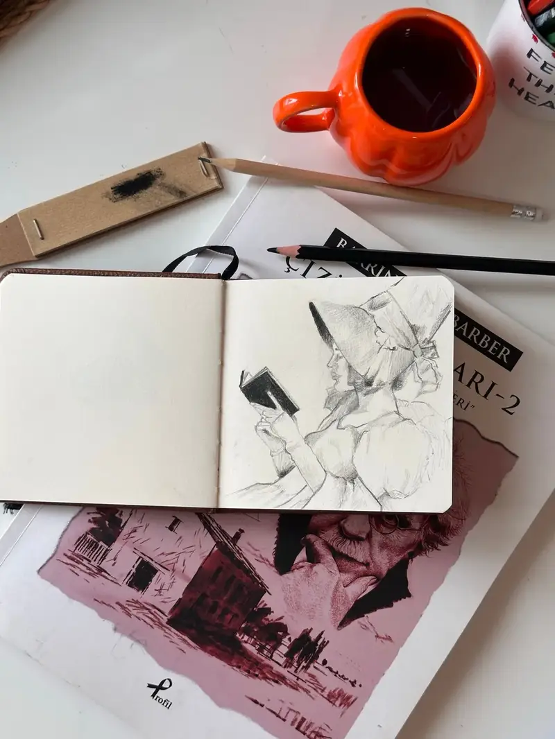Themed sketchbook pages with a sketchbook pencils and coffee workspace