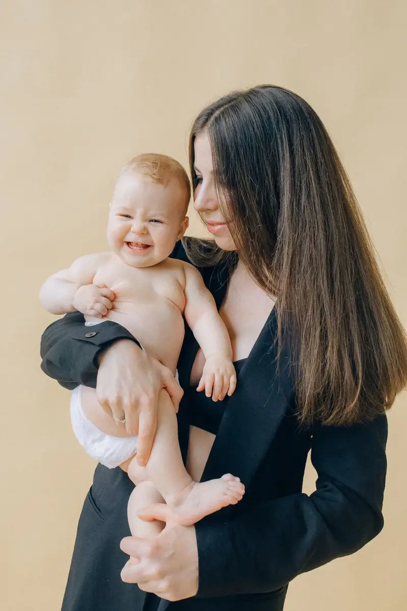Baby social smile milestone around two months with mother and baby