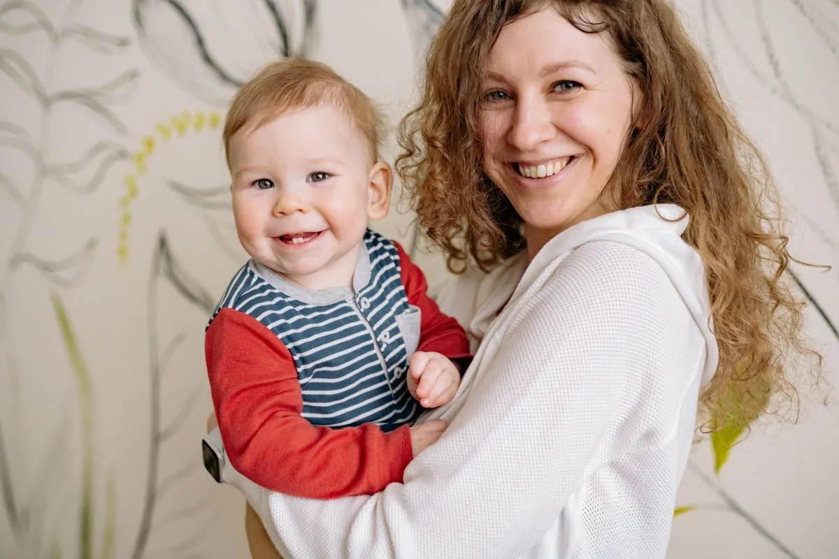 When babies start smiling with a mother holding her smiling baby
