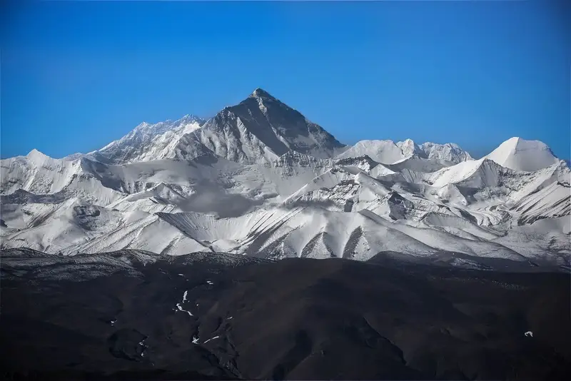 Mount Everest surrounded by snowy peaks answering where is everest on the Nepal Tibet border