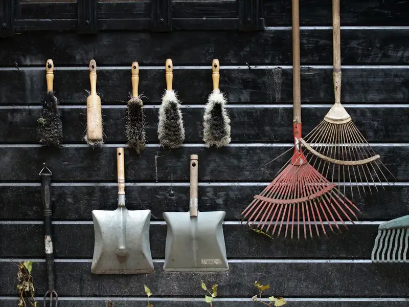 Garden hand tools hanging neatly on a wall after cleaning, ready to donate