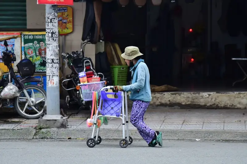 Elderly woman using a walker with a basket, the kind to donate where to donate medical equipment