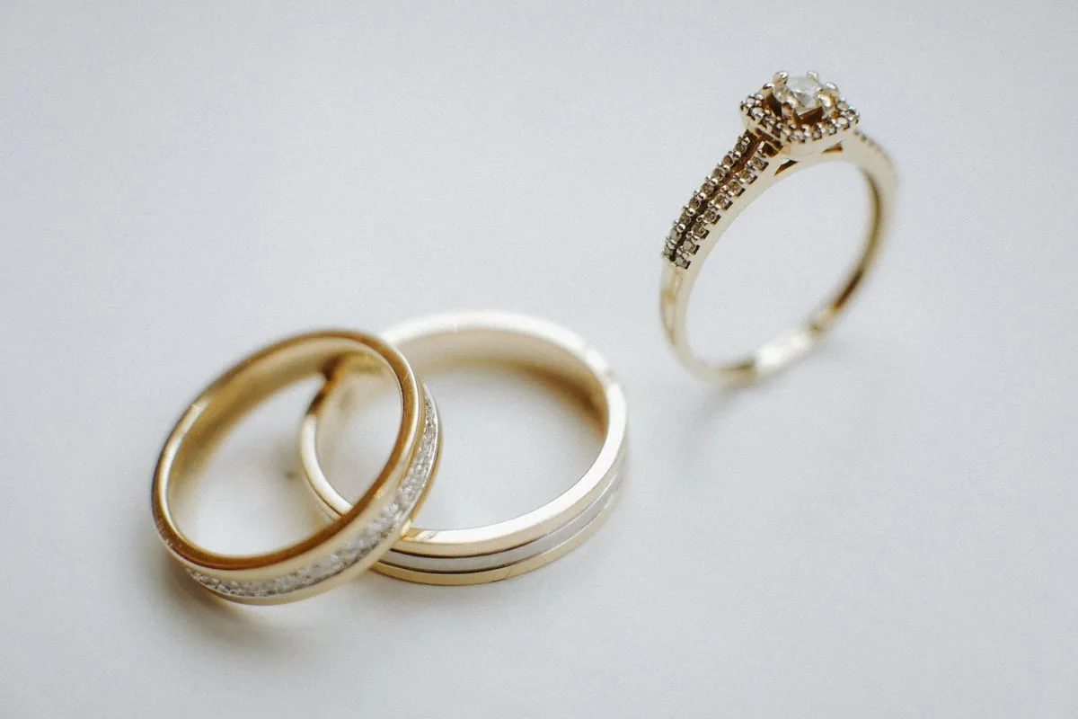 Gold wedding bands and diamond engagement ring showing where to sell jewelry online for fine pieces