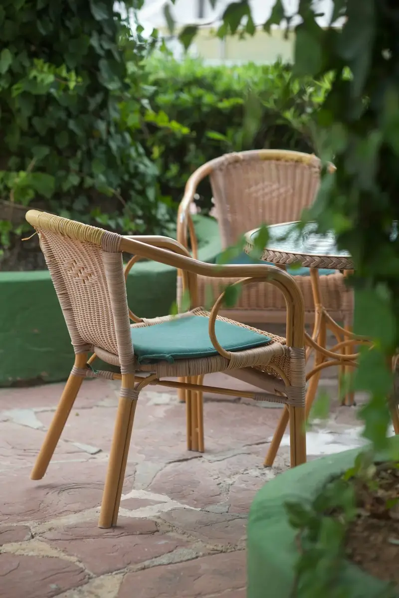 Wicker chairs in a garden showing resin wicker where to sell outdoor furniture material value